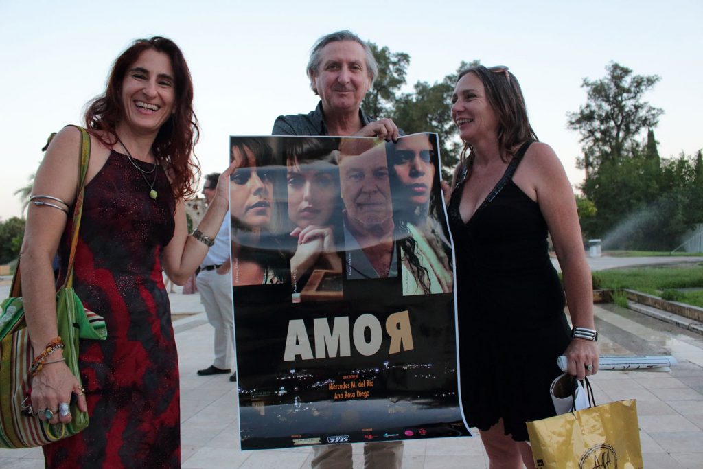 Ana Rosa Diego, Mercedes del Río y Sebastián Haro junto al cartel del cortometraje Amor